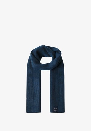 Scaldino blu scuro lavorato a maglia con un motivo a coste testurizzato, realizzato in un materiale morbido e dotato di un’etichetta in basso con le istruzioni per la cura.