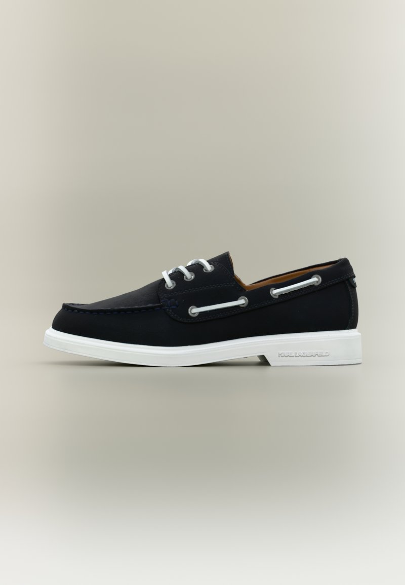 Μαύρο δερμάτινο παπούτσι σκάφους με λευκά κορδόνια και σόλα, με πλευρικές τρύπες για κορδόνια και το λογότυπο "Karl Lagerfeld" ανάγλυφο στη φτέρνα της σόλας.