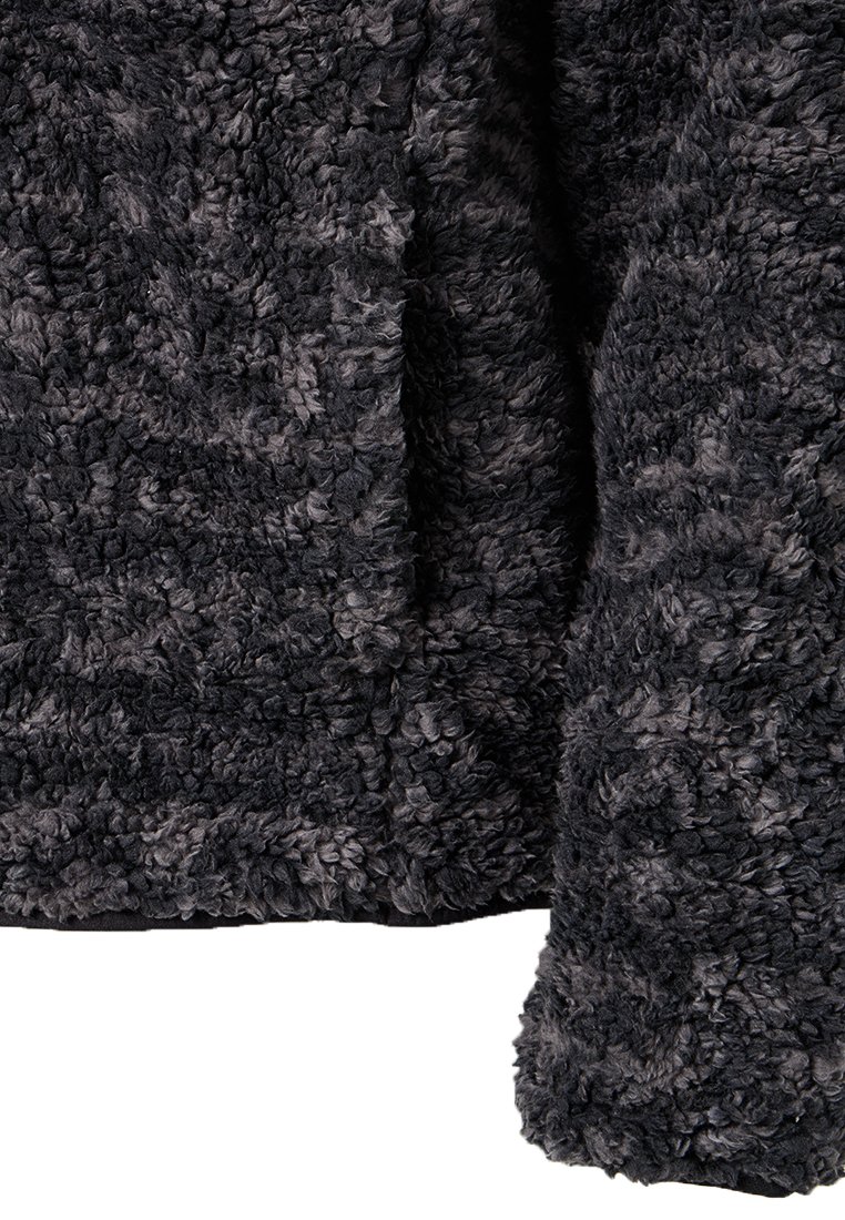 Flauschiger schwarzer und grauer Stoff mit einer strukturierten, plüschigen Oberfläche. Das Material wirkt weich und dick und eignet sich gut für Oberbekleidung oder Loungewear.