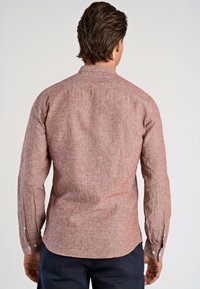 Camicia a maniche lunghe rossa con trama, colletto a punta, polsini abbottonati e orlo curvo, caratterizzata da un sottile motivo intrecciato.