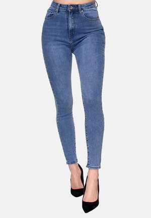 Jeans skinny a vita alta in denim blu medio, con cinque tasche, passanti per cintura e una leggera scoloritura. Abbinati a tacchi alti neri.