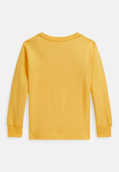 Majica z dolgimi rokavi v živahni rumeni barvi, izdelana iz mehke bombažne tkanine. Ima okrogel izrez in manšete; gladka tekstura brez vidnih vzorcev ali grafik.