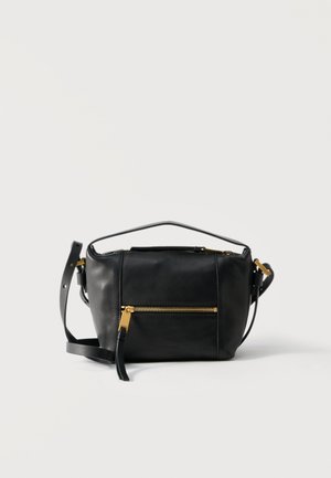 Geantă crossbody din piele neagră, cu fermoar auriu la buzunarul din față și cu curea de umăr reglabilă, așezată pe un fundal deschis simplu.