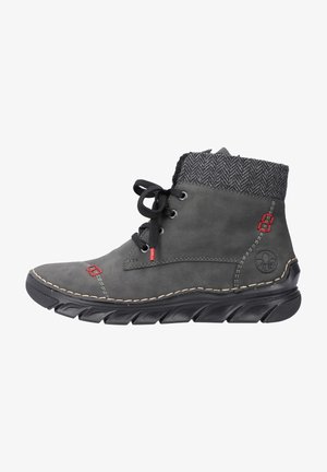 Bottines en cuir gris avec un col en maille noire texturée, des accents rouges et une semelle en caoutchouc noire présentant un motif ondulé. Design à lacets.
