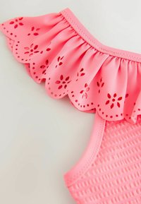 Roza kopalke s teksturiranim telesom in nagubanim ramenom, poudarjenim z lasersko izrezanimi cvetličnimi vzorci in valovitimi robovi.