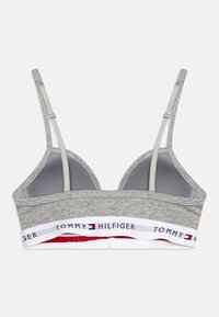 Szary biustonosz braletka z regulowanymi ramiączkami, miękka tkanina oraz biała taśma z logo "TOMMY HILFIGER" z czerwonymi i niebieskimi akcentami.