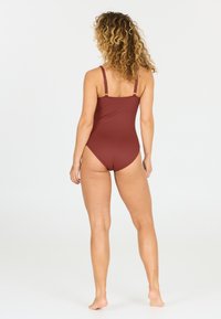 Maillot de bain une pièce bordeaux avec bretelles réglables, présentant une finition texturée et une conception à taille haute. La vue de dos montre une couverture minimale.