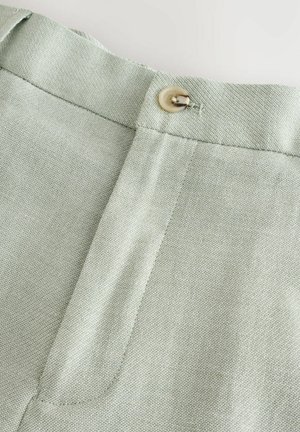 Pantaloni verzi deschis, cu un material texturat, un tiv neted și un sistem de închidere cu nasture în partea de sus.