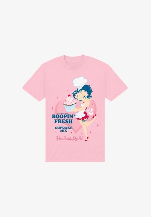 Jasnoróżowa koszulka z krótkim rękawem z postacią z kreskówki trzymającą babeczkę. Grafika zawiera tekst, kolorowe akcenty oraz tło w serduszka.