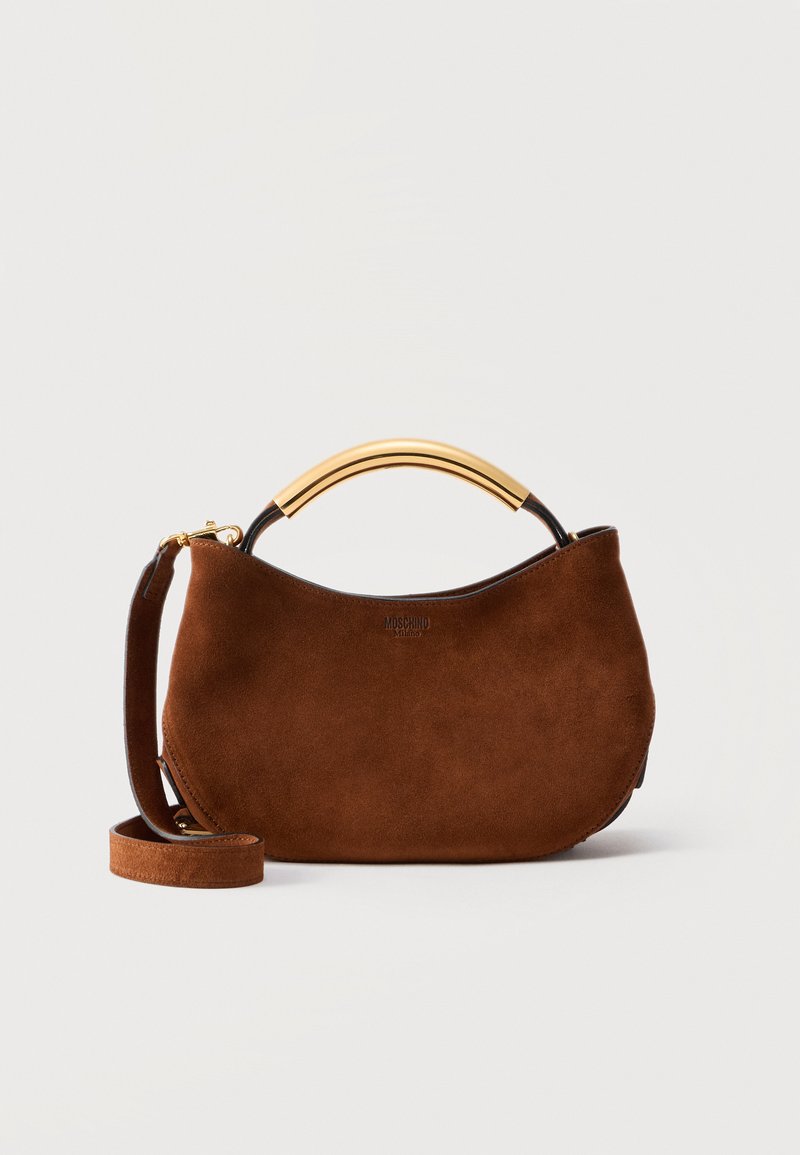 Καφέ σουέντ γυναικεία τσάντα με καμπυλωτή χρυσή λαβή στην κορυφή, αποσπώμενο ιμάντα ώμου και λογότυπο "Moschino Milano" μπροστά.