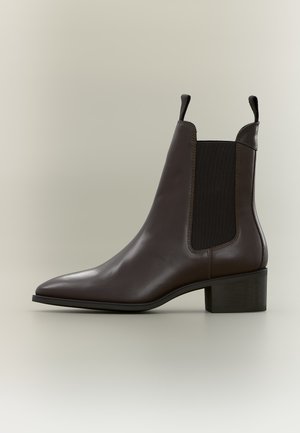Bottine en cuir marron foncé avec panneaux latéraux élastiques noirs, languettes sur l'avant et l'arrière, et un petit talon carré.