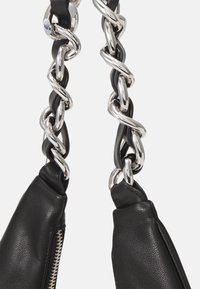 Zwarte leren handtasriem met een chunky zilveren kettinglinkdesign, met een gestructureerde afwerking en een ritssluiting aan één zijde.