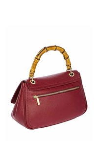Sac à main en cuir bordeaux avec une poignée en bambou, des garnitures dorées et une poche zippée à l'avant. Il présente une forme structurée et une surface texturée.