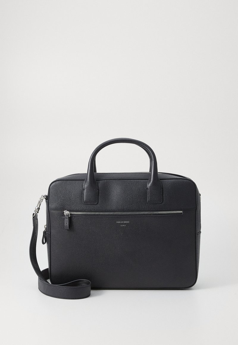 Sac à ordinateur portable en cuir noir avec une finition texturée, deux poignées supérieures, une bandoulière amovible et une poche zippée à l'avant.