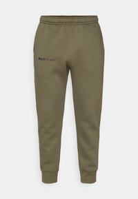 Calças de treino verde-azeitona com um design de perna afunilada, cintura elástica e o logótipo "PARIS" e Nike em preto na coxa esquerda. Textura suave.