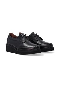 Schwarze Leder-Schnürschuhe mit glänzender, strukturiertem Vorderseite und dicken, schwarzen Plateausohlen, nebeneinander auf einem weißen Hintergrund gezeigt.
