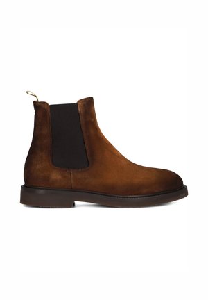 Bruine suède Chelsea-boot met zwart elastisch zijpaneel en donkerbruine zool, gezien vanaf de binnenkant.