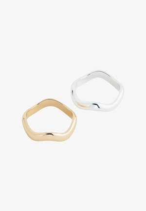 Two rings, one gold and one silver, with a smooth, wavy design. Each has a polished finish and an irregular, organic shape.