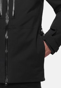 Black waterproof jacket with a textured surface, featuring a central zipper and zippered pocket, and adjustable cuffs.