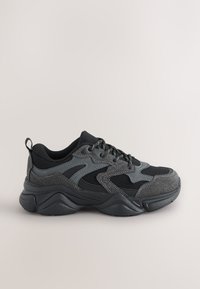 Chaussures de sport noires et grises avec une tige en mesh, un col rembourré et des accents texturés ; semelle incurvée conçue pour le confort et le soutien.
