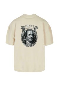 Krēms krāsas pārāk liela T-krekls ar melnu grafiku, kurā attēlots Benžamins Franklins dekoratīvā ovālā ar tekstu "NAUDA NENOLIEK".