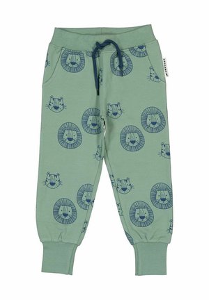 Lys grønne sweatpants med et gentaget mønster af marineblå løveansigt, elastisk talje med snøre og afsluttede ankler. Blødt bomuldsstof.
