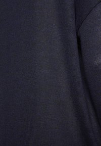 Tecido azul-marinho escuro com uma textura tecida, apresentando variações sutis na cor e um acabamento suave.