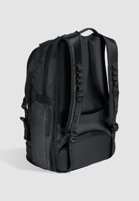 Mochila negra con respaldo acolchado, correas ajustables, compartimentos con cremallera y tejido texturizado en un diseño elegante y ergonómico.