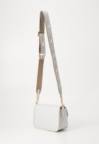 Borsa bianca con motivo in rilievo, caratterizzata da una forma rettangolare, tracolla beige con logo e dettagli in hardware color oro rosa.