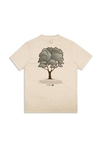 Béžové bavlněné tričko s stylizovanou šedou grafikou stromu na zadní straně, doplněné textem popisujícím inspiraci kolekce.