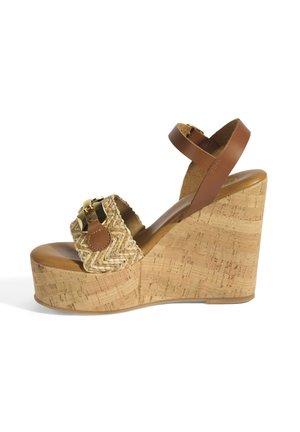 Wedge sandaal met een kurkplatform, een geweven stro bovenstuk en een bruin leren enkelbandje. Voorzien van een gouden accent aan de voorkant.