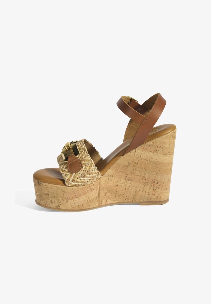 Sandale à talon compensé avec une plateforme en liège, une tige en paille tressée et une sangle à la cheville en cuir marron. Présente un accent doré sur le devant.