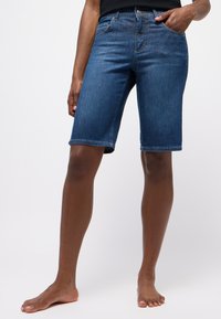 Denim shorts in donkerblauw met een klassieke snit, voorzien van een middelhoge taille, vijf-vakken ontwerp en een nette zoom op knielengte.