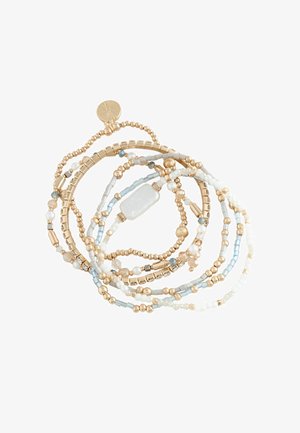 Multi-strand bracelet with gold, white, blue beads, and a rectangular white stone charm on a white background.