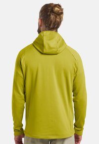 T-shirt à manches longues avec capuche en vert lime vif, doté d'un tissu texturé et d'un design de couture ergonomique. Finition lisse avec des poignets ajustés.