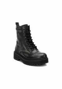 Botas negras hasta el tobillo hechas de cuero sintético, con puntera redonda, cordones en la parte delantera y suela texturizada con un diseño grueso.