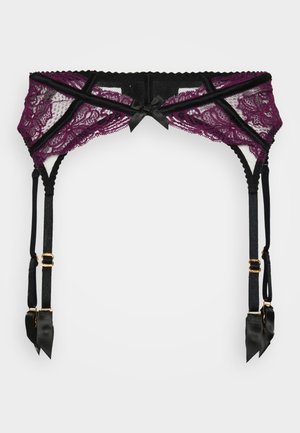 Violet nėriniuotas kojinės diržas su juodais satino akcentais, turintis reguliuojamus dirželius ir auksinius elementus. Skoningas kaspino dekoras centre.