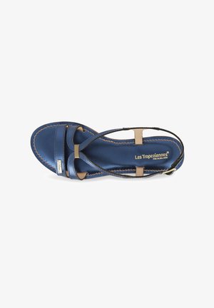 Blauwe synthetische sandaal met beige accenten, voorzien van kruisbanden en een platte zool. Stiksels zichtbaar langs de randen. Lichtgewicht ontwerp.