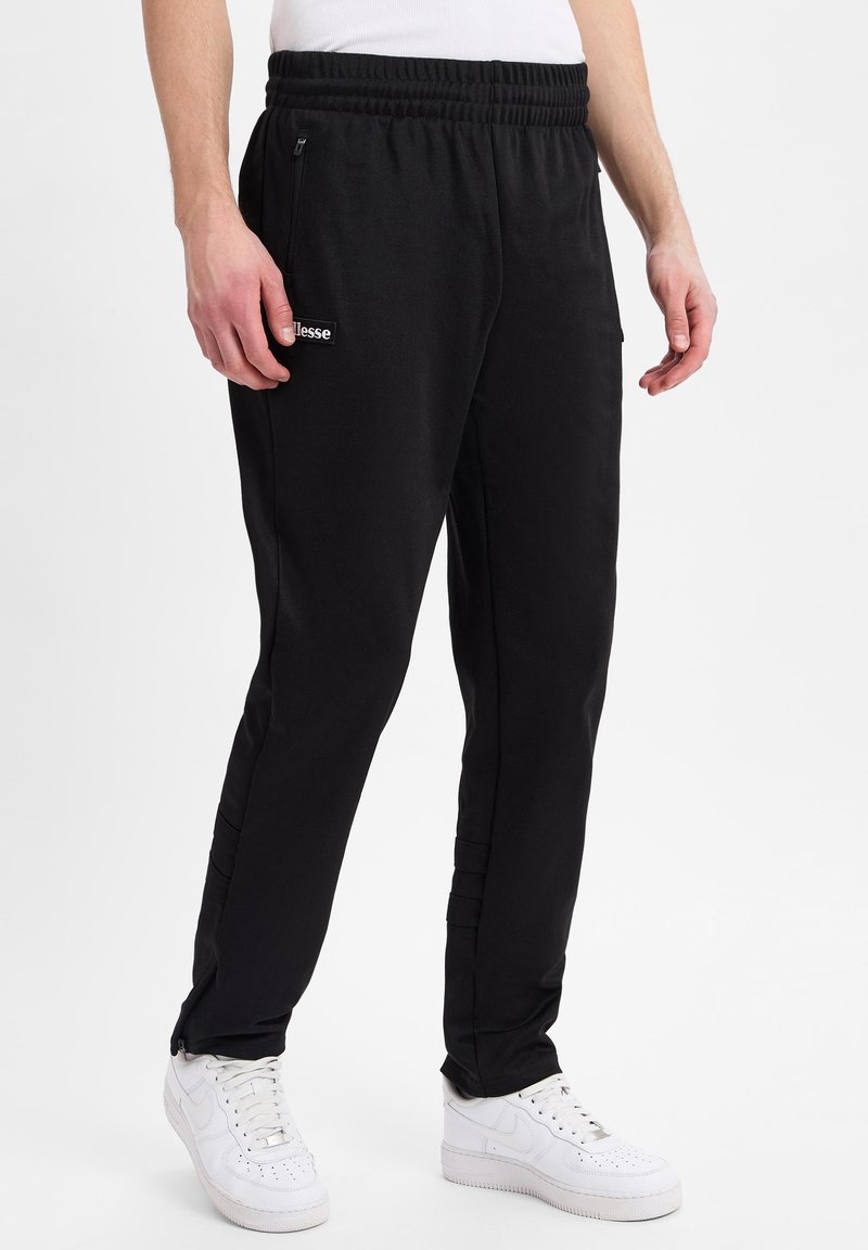 Schwarze Sporthosen mit einer Kordelzugtaille, Reißverschlusstaschen an den Seiten und dezentem Branding. Hergestellt aus einem weichen, elastischen Stoff.
