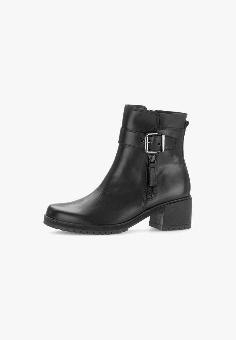 Bottine en cuir noir avec un bout rond, fermeture éclair sur le côté, accent de boucle au niveau de la cheville et un talon carré. Semelle en caoutchouc texturée.