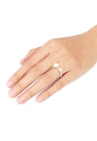 Sølvring med to perler, en større og en mindre, sat på en hånd. Designet har en glat ring med en elegant kurve.