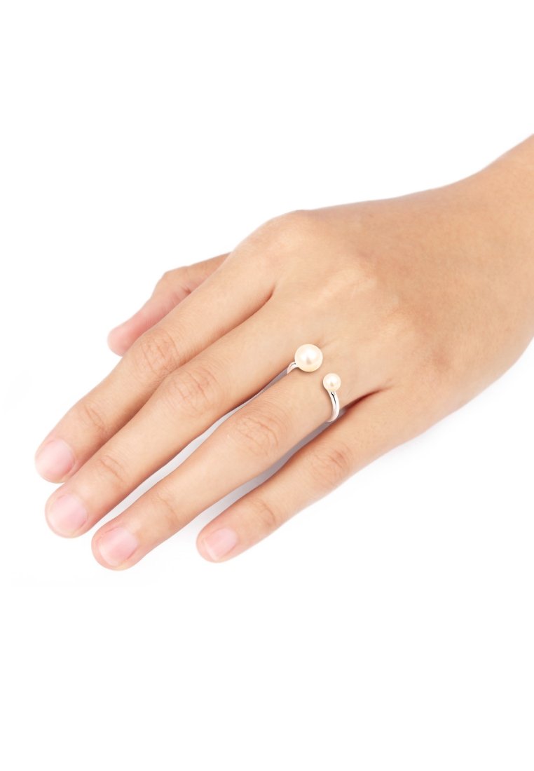 Sølvring med to perler, en større og en mindre, sat på en hånd. Designet har en glat ring med en elegant kurve.