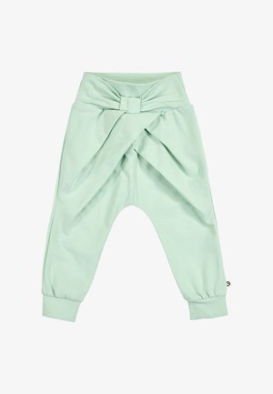 Pantaloni per bambini verde chiaro con una fascia alta in vita che presenta un grande fiocco e orli risvoltati alle caviglie.