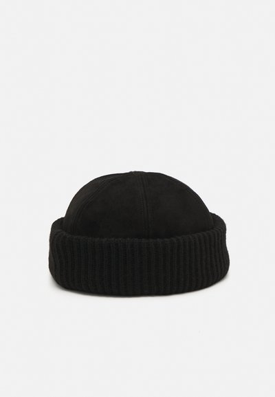 Cappello beanie nero con un bordo a coste texturizzato e una parte superiore liscia e arrotondata simile alla pelle scamosciata. Design semplice e monocromatico.