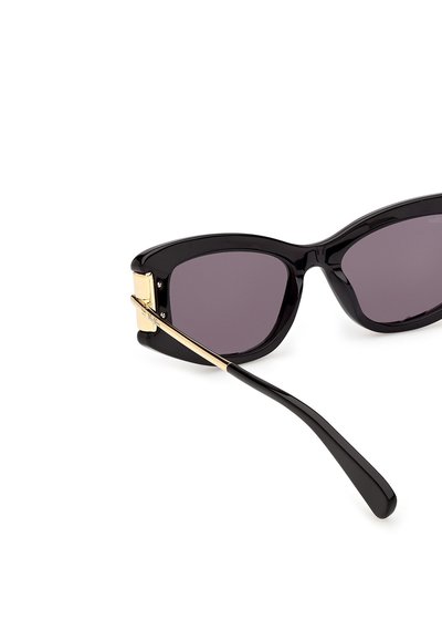 Black cat-eye sunglasses with dark lenses and gold metal accents on the temples, shown against a white background.