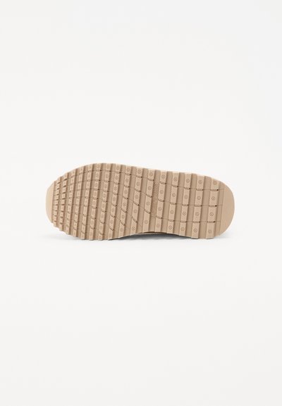 Suela de goma con patrón texturizado, que presenta estrías y agarres circulares para tracción. Color marrón claro, forma plana, diseñada para la durabilidad.