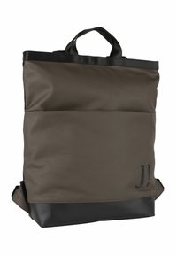 Brun tygryggsäck med svart botten. Har dubbla handtag på toppen och justerbara axelremmar. Slät textur med logotypdetalj på framsidan.