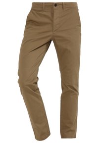 Tan chinos med rak benform, tillverkade av bomullstwill. Har en framknäppning, sidofickor och en mjuk yta.