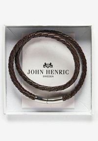 Brun flätad läderarmband med metalldetalj, presenterat i en vit box med varumärket "John Henric" på ett kort inuti.