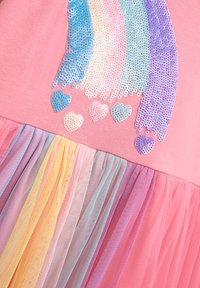 Rosa Kleid mit einem paillettenverzierten Regenbogenmuster und Herzakzenten. Der Rock ist aus mehrlagigem, mehrfarbigem Tüll in Pastellfarben.